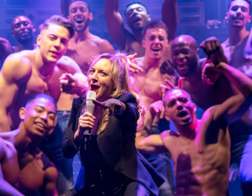 Woman signing into microphone surrounded by cast of Magic Mike